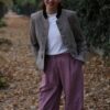 Femme souriante en veste grise et pantalon rayé