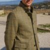 Homme en veste en tweed devant paysage montagneux