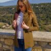 Femme ajustant veste devant paysage montagneux